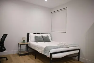 a white room with a bed with a window at Luxe Ensuite in Shared Home-Minutes to USC in Los Angeles