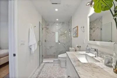 a bathroom with a shower and a toilet and a sink at Charming Encino Retreat with Pool in Encino