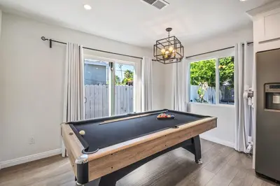 a pool table in a living room with at Charming Encino Retreat with Pool in Encino