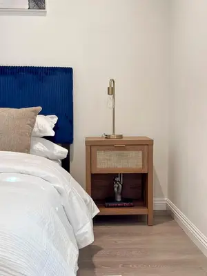 a bedroom with a bed and a nightstand with a lamp at Charming Encino Retreat with Pool in Encino