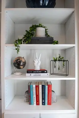 a white book shelf with books and plants at Charming Encino Retreat with Pool in Encino