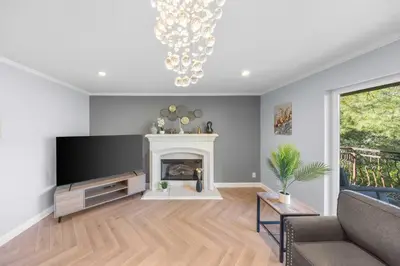 a living room with a fireplace and a chandelier at Tranquil Hideaway Private Retreat with Mountain Views in Tujunga