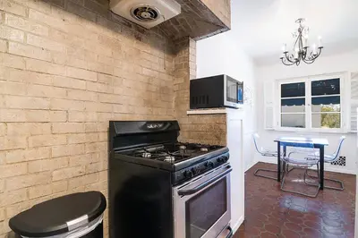 a kitchen with a black stove and a table at Cozy Beverly Hills Studio Near Shopping with Kitchen in Los Angeles