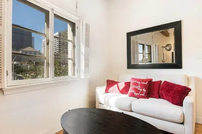 a living room with a white couch and a table at Cozy Beverly Hills Studio Near Shopping with Kitchen in Los Angeles