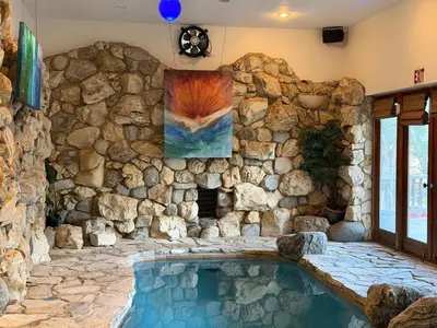 a pool in a room with a stone wall at Family Nature Retreat Near LA with Indoor Grotto Pool in Simi Valley
