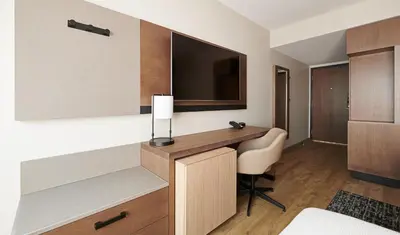 a hotel room with a desk and a television at Hyatt Place Ontario Airport in Ontario