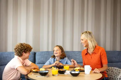 a woman and two children sitting at a table at Hyatt Place Ontario Airport in Ontario