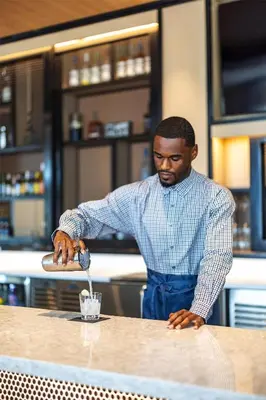 a man standing at a counter preparing a drink at Hyatt Place Ontario Airport in Ontario