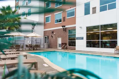 a swimming pool in front of a building at Hyatt House Ontario Airport in Ontario