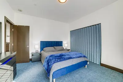 a bedroom with a bed with a blue head board at Fully Updated! Prime Riverside Spot Near Dtwn in Riverside