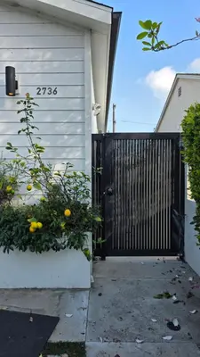 a black gate on the side of a house at Modern Studio with Kitchen Parking Near Beverly Hills and Culver City in Los Angeles