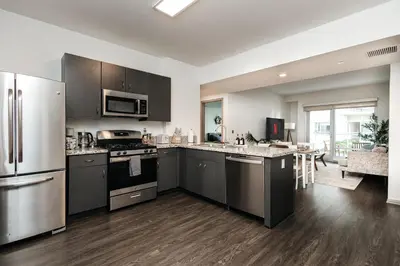 a large kitchen with stainless steel appliances and a living room at Spacious 2bedroom in Hollywood with Parking Gym Pool in Los Angeles
