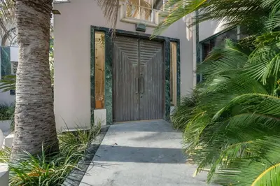 a wooden door on a house with palm trees at The Sinatra House- Fully Furnished! in Los Angeles