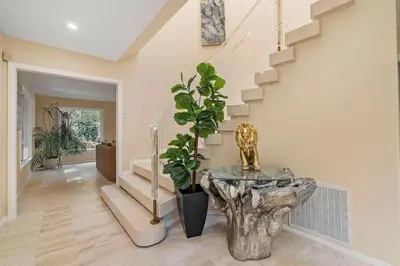 a foyer with a marble table and stairs at The Sinatra House- Fully Furnished! in Los Angeles