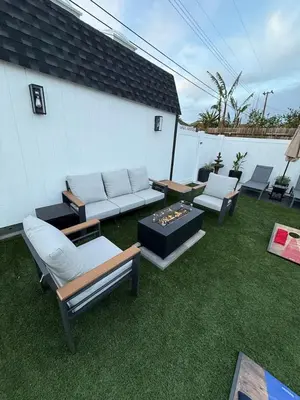a backyard with a couch and chairs on the grass at Private 3BR Home - Hot Tub, Yard, Arcade & Parking in Simi Valley