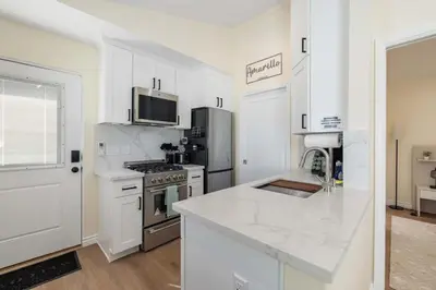 a kitchen with white cabinets and a stove top oven at Luxury 1BR Suite Kitchen, Fireplace, Laundry, BBQ in Simi Valley