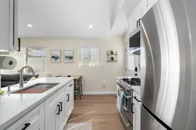 a kitchen with white cabinets and a stainless steel refrigerator at Luxury 1BR Suite Kitchen, Fireplace, Laundry, BBQ in Simi Valley
