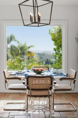 a dining room with a table and chairs and a large window at New Listing Elevated Hillside Living by Colby & Conrad in Los Angeles