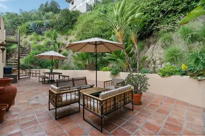 a patio with tables and chairs and umbrellas at New Listing Elevated Hillside Living by Colby & Conrad in Los Angeles