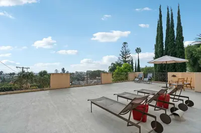 a patio with picnic tables and an umbrella at New Listing Elevated Hillside Living by Colby & Conrad in Los Angeles