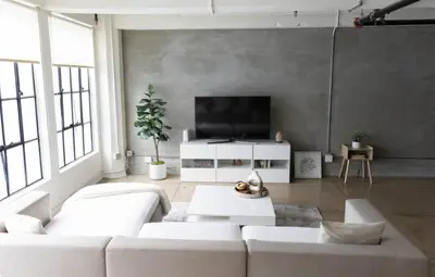 a living room with a white couch and a flat screen tv at Chic urban loft steps from dining and shopping in Los Angeles