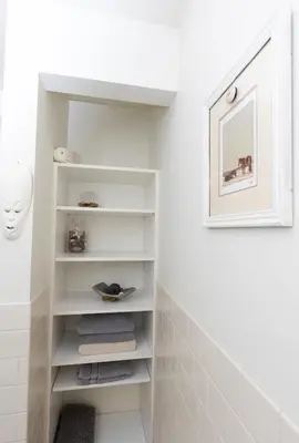 a bathroom with white walls and white shelves at Chic urban loft steps from dining and shopping in Los Angeles