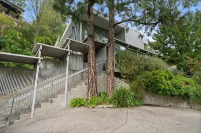 a house with two palm trees and stairs at New Listing Modern Hollywood Hills Sanctuary by Colby & Conrad in Los Angeles