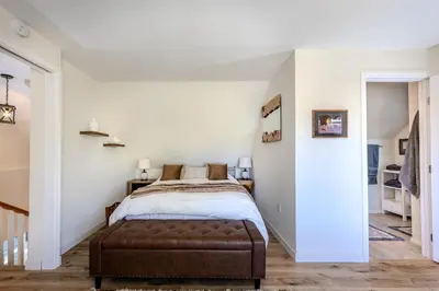 a bedroom with a bed with a brown ottoman at Luxury Lakefront Retreat,HotTub,EV Charge,Fire Pit in Big Bear Lake