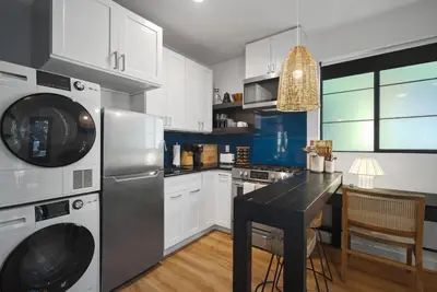 a kitchen with white cabinets and a black counter top at Modern Luxe Studio in East Los Angeles in Los Angeles