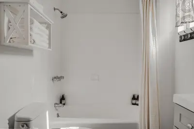 a white bathroom with a toilet and a shower at Elegant 3-bedroom home Retreat in East Los Angeles in Los Angeles