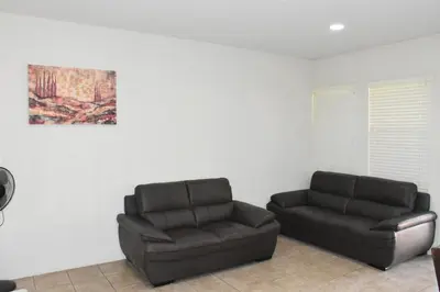 a living room with two chairs and a couch at Cozy 2-Bedroom Home in Eastvale in Corona