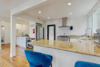 a kitchen with a counter and two blue chairs at Mountain Playhouse in Lake Arrowhead