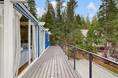 a wooden walkway leading to a porch on a house at Mountain Playhouse in Lake Arrowhead