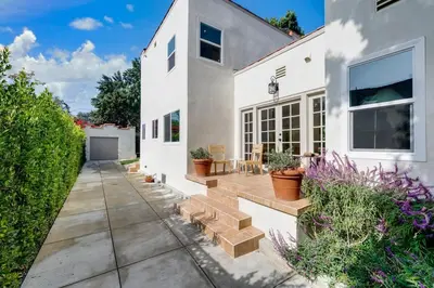 a white house with a patio with potted plants at Chic WeHo Retreat near Sunset Blvd in Los Angeles