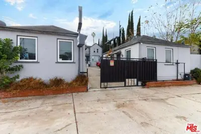 a white house with a black gate in a driveway at Cozy Studio Apt Studio City Unit 5 in Los Angeles
