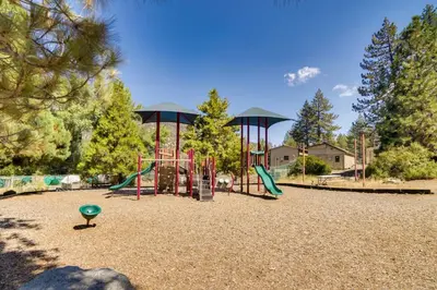 a playground with two swings and a slide at Outdoor Oasis in Pine Mountain Club! Cabin Getaway in Pine Mountain Club