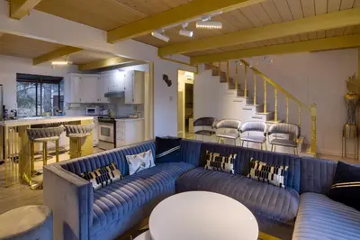 a living room with a blue couch and chairs at Outdoor Oasis in Pine Mountain Club! Cabin Getaway in Pine Mountain Club