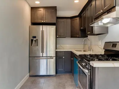 a kitchen with wooden cabinets and a stainless steel refrigerator at Cozy 1 Bedroom Tarantino Unit Studio City in Los Angeles