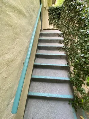a set of stairs with blue railing next to a building at Cozy Studio by Rodeo Drive in Los Angeles