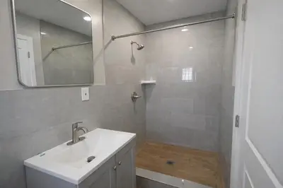 a bathroom with a sink and a shower with a mirror at Carlton Motel in Los Angeles