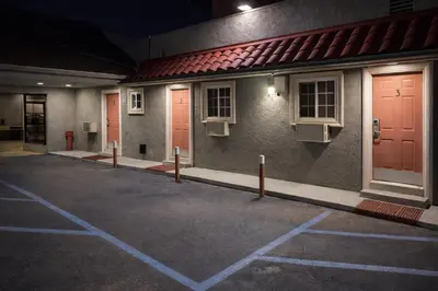 a row of red doors on the side of a building at Carlton Motel in Los Angeles