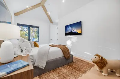 a bedroom with a bed and a tv on the wall at Colfax Estate in Los Angeles