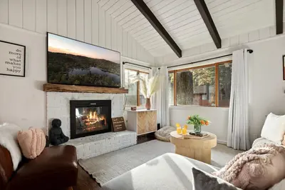 a living room with a fireplace and a tv at The Willow Cabin in Big Bear Lake