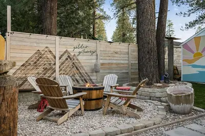 a backyard with chairs and a fire pit and a fence at The Willow Cabin in Big Bear Lake