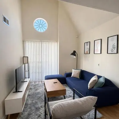 a living room with a blue couch and a tv at Evera Residence- 1Bed with Free Parking, Pool and Sauna in Los Angeles