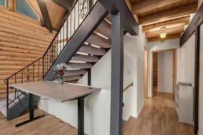 a wooden staircase with a wooden table in a house at Vista Lodge! 20 min to Silverwood Lake in Cedarpines Park