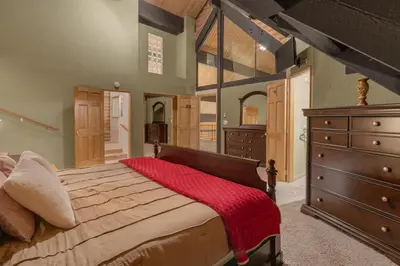 a bedroom with a large bed with a red blanket on it at Vista Lodge! 20 min to Silverwood Lake in Cedarpines Park