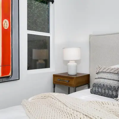 a bedroom with a bed and a table with a lamp at Modern Mid-Wilshire Escape Prime Spot in Los Angeles