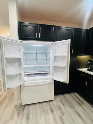 an empty refrigerator in a kitchen with black cabinets at Stylish & Fully Renovated Home! in Oxnard