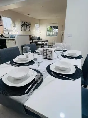 a table with plates and wine glasses on it at Stylish & Fully Renovated Home! in Oxnard